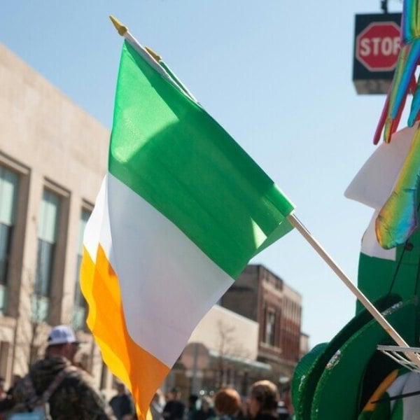 A photography of the Irish flag being flown in the street