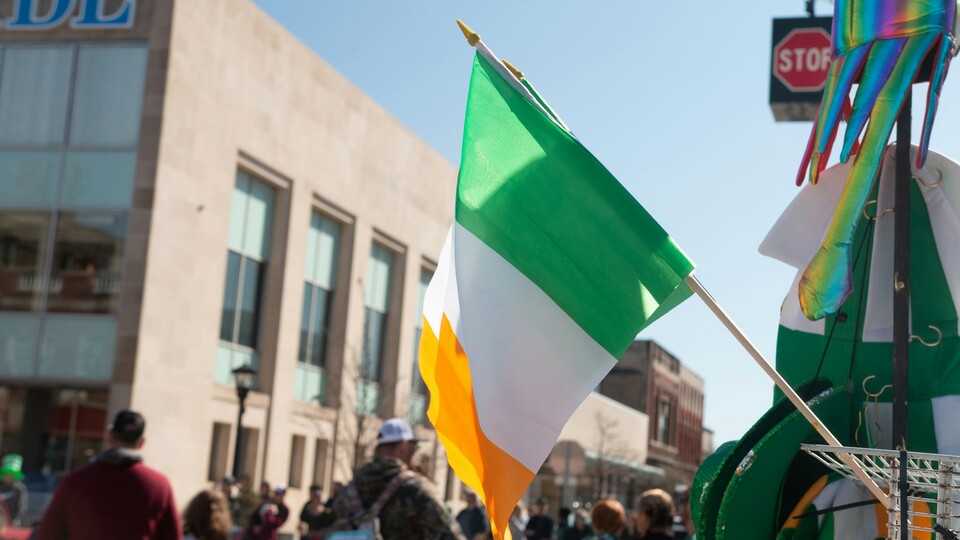 A photography of the Irish flag being flown in the street