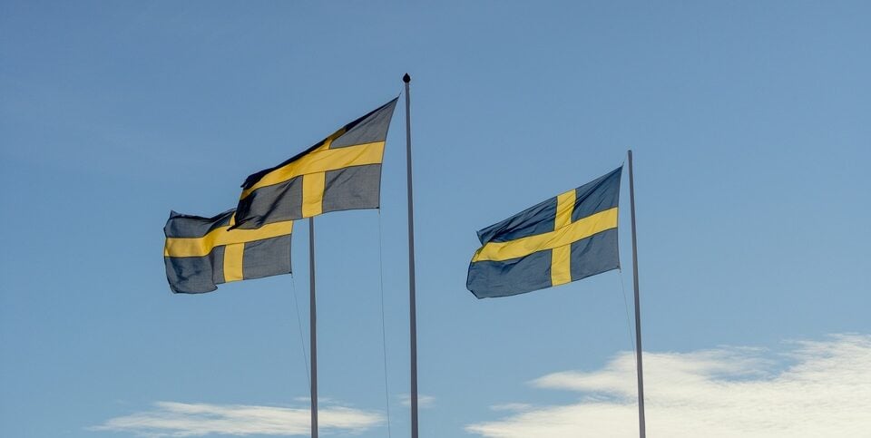 Three Swedish flags being flown