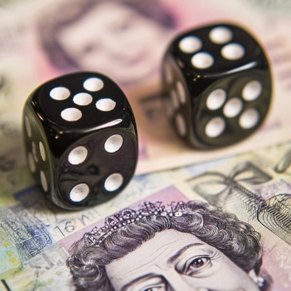 Stock Image of Dice Sitting on top of UK Money