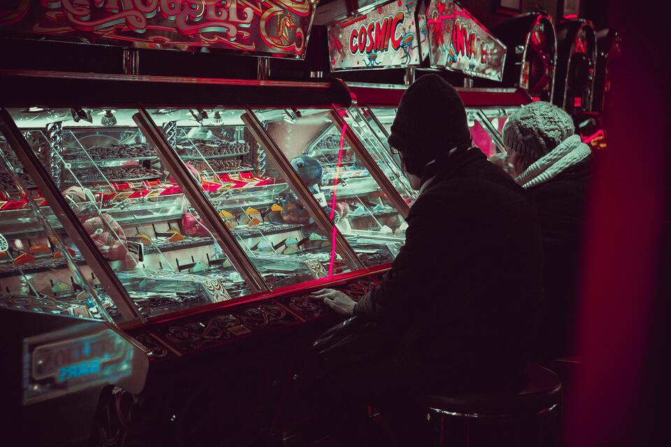 A photograph of a man sitting at an amusements or arcade game 