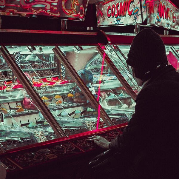 A man sitting at an arcade amusements machine